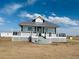 Charming home features a metal roof and a lovely front porch with white lattice accents and freshly painted trim at 17362 County Road 29, Platteville, CO 80651