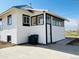 Side exterior shows an enclosed porch area and concrete driveway with convenient side door access at 17362 County Road 29, Platteville, CO 80651
