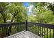 View of the wooded backyard from the back deck with metal railing at 761 Carr St, Lakewood, CO 80214