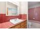 Retro bathroom featuring red tiling, vanity with sink, and a combination tub and shower at 761 Carr St, Lakewood, CO 80214