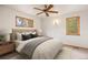 Cozy bedroom with a ceiling fan, warm lighting, and view of the landscape from the windows at 761 Carr St, Lakewood, CO 80214