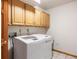 Functional laundry room equipped with cabinetry, a washing machine, and a dryer at 761 Carr St, Lakewood, CO 80214