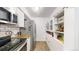 Bright kitchen offers a pantry, butcher block counters, stainless steel appliances and white cabinetry at 1242 S Crystal Way, Aurora, CO 80012