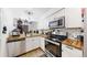 Bright kitchen features butcher block counters, stainless steel appliances, and white cabinetry at 1242 S Crystal Way, Aurora, CO 80012