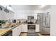 Bright kitchen with butcher block counters, stainless steel appliances, and white cabinetry at 1242 S Crystal Way, Aurora, CO 80012