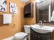 Cozy bathroom features a toilet, sink, dark wood cabinets, and an ornate framed mirror at 740 N Sherman St # 208, Denver, CO 80203