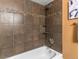 A shower over a bathtub showcases earth tone tile and convenient built-in shelves at 740 N Sherman St # 208, Denver, CO 80203