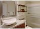 Bathroom features a sleek vessel sink, modern vanity, decorative shelving, and a glass-enclosed shower for a spa-like experience at 11358 W 85Th Pl # E, Arvada, CO 80005