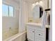 Bright bathroom featuring a tub, white vanity, oval mirror and decorative lighting at 11358 W 85Th Pl # E, Arvada, CO 80005