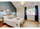 Comfortable bedroom showcasing a queen bed, stylish decor, natural light from the window, and complementing hardwood floors at 11358 W 85Th Pl # E, Arvada, CO 80005