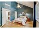 Bedroom featuring a queen bed, stylish decor, natural light from the window, en-suite laundry and complementing hardwood floors at 11358 W 85Th Pl # E, Arvada, CO 80005