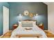 Bedroom featuring a queen bed, stylish decor, natural light and complementing hardwood floors, offering a cozy retreat at 11358 W 85Th Pl # E, Arvada, CO 80005