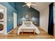 Bedroom featuring a queen bed, stylish decor, natural light from the window, en-suite laundry and complementing hardwood floors at 11358 W 85Th Pl # E, Arvada, CO 80005