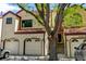 Townhome exteriors showing unit numbers and front-facing garages with mature shade tree at 11358 W 85Th Pl # E, Arvada, CO 80005