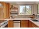 This kitchen features wooden cabinets, stainless steel appliances, a large window and a decorative tile backsplash at 11358 W 85Th Pl # E, Arvada, CO 80005