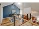 Upstairs office space with a blue accent wall, modern chandelier, and wood floors at 11358 W 85Th Pl # E, Arvada, CO 80005