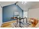 Office space with a blue accent wall, vaulted ceiling and hardwood floors at 11358 W 85Th Pl # E, Arvada, CO 80005
