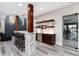 Stylish home bar area with a stone-clad counter, wooden shelving, and seating for entertaining at 5409 Sedona Dr, Parker, CO 80134