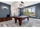Finished basement featuring a pool table, stone accents, and a large window with natural light at 5409 Sedona Dr, Parker, CO 80134