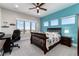 Bright bedroom with a blue accent wall, ceiling fan, large windows offering a neighborhood view at 5409 Sedona Dr, Parker, CO 80134