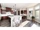 Bright, spacious kitchen with large island, stylish pendant lighting, stainless steel appliances, and dark wood cabinetry at 5409 Sedona Dr, Parker, CO 80134