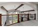 Loft with wood beams and iron railing offering views of the living room below and the neighborhood beyond at 5409 Sedona Dr, Parker, CO 80134
