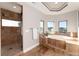 Elegant main bathroom features a soaking tub, large shower, and travertine tile, creating a spa-like retreat at 5409 Sedona Dr, Parker, CO 80134