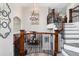 Elegant staircase with wrought iron railing, and view into the dining room featuring an adjacent stone wall at 5409 Sedona Dr, Parker, CO 80134