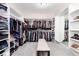 Spacious walk-in closet with ample shelving, hanging space, mirrored wall and a central bench at 5409 Sedona Dr, Parker, CO 80134