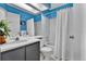 Well-lit bathroom with blue walls, a shower-tub combo, a large mirror, and a dark vanity at 14430 W Yale Pl, Lakewood, CO 80228