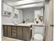 Well-lit bathroom featuring double sinks, a skylight, and a neutral color scheme at 14430 W Yale Pl, Lakewood, CO 80228