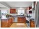 Well-lit kitchen featuring stainless steel appliances, dark granite counters, and custom cabinetry at 14430 W Yale Pl, Lakewood, CO 80228