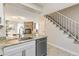 Kitchen area with stainless steel appliances, granite countertops, and a view into the living room and staircase at 9758 W Cornell Pl, Lakewood, CO 80227