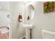Cozy powder room with a pedestal sink, decorative mirror and a view of the hallway at 6393 N Malaya St, Aurora, CO 80019