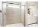 Tiled shower with frameless glass door, window, and a view into the bathroom at 6393 N Malaya St, Aurora, CO 80019