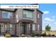 Modern two-story townhome featuring neutral siding, stone accents, covered entryway, and well-maintained landscaping at 6393 N Malaya St, Aurora, CO 80019