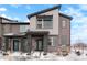 Modern townhome with a neutral color scheme, partial stone accents and a covered front entryway at 6393 N Malaya St, Aurora, CO 80019