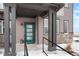 Welcoming home entrance featuring a teal front door, modern lighting, and a convenient ramp for accessibility at 6393 N Malaya St, Aurora, CO 80019