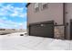 Attached two-car garage with modern door and exterior stone accents for added curb appeal and convenience at 6393 N Malaya St, Aurora, CO 80019