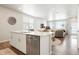 Modern kitchen with stainless steel appliances, island, and open floor plan into the living area at 6393 N Malaya St, Aurora, CO 80019