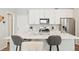 Bright kitchen with a large island, white cabinets, stainless appliances and stylish pendant lights at 6393 N Malaya St, Aurora, CO 80019