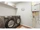 Modern laundry room features a front loading washer and dryer, built-in shelving and water heater at 6393 N Malaya St, Aurora, CO 80019