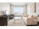 Bright and airy sitting area featuring a large window, comfortable seating and stylish decor at 6393 N Malaya St, Aurora, CO 80019