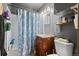 Small bathroom with shower/tub combo, wood vanity, and floral shower curtain at 2229 S Bannock St, Denver, CO 80223