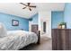 Spacious bedroom features blue walls, a comfortable bed, and a glimpse of an ensuite bathroom at 133 Heritage Ave, Castle Rock, CO 80104