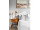 Close-up of a bedroom featuring a nightstand with decorative lamp, and textured white bedding at 133 Heritage Ave, Castle Rock, CO 80104