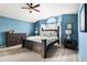 Inviting bedroom with blue walls, a large bed with white linens, and a charming arched window at 133 Heritage Ave, Castle Rock, CO 80104