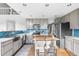 Bright kitchen with gray cabinets, blue backsplash, center island, stainless steel appliances, and hardwood floors at 133 Heritage Ave, Castle Rock, CO 80104