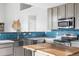 Modern kitchen features stainless steel appliances, a farmhouse sink, and a butcher block island at 133 Heritage Ave, Castle Rock, CO 80104