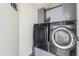 Modern laundry room features front-loading washer and dryer and gray cabinetry at 133 Heritage Ave, Castle Rock, CO 80104